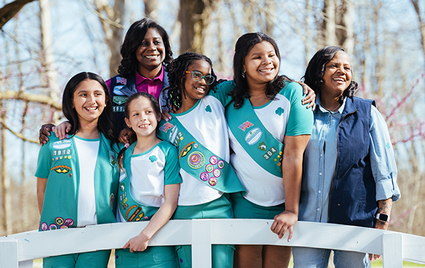Junior Girl Scout smiling, showing off her vest with badges
