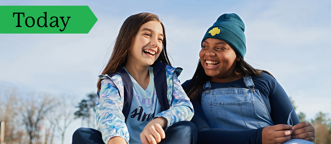 Two Girl Scouts sitting in a field