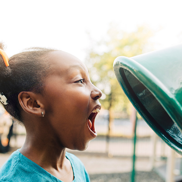 Young Girl Scout playing on playground equipment outside